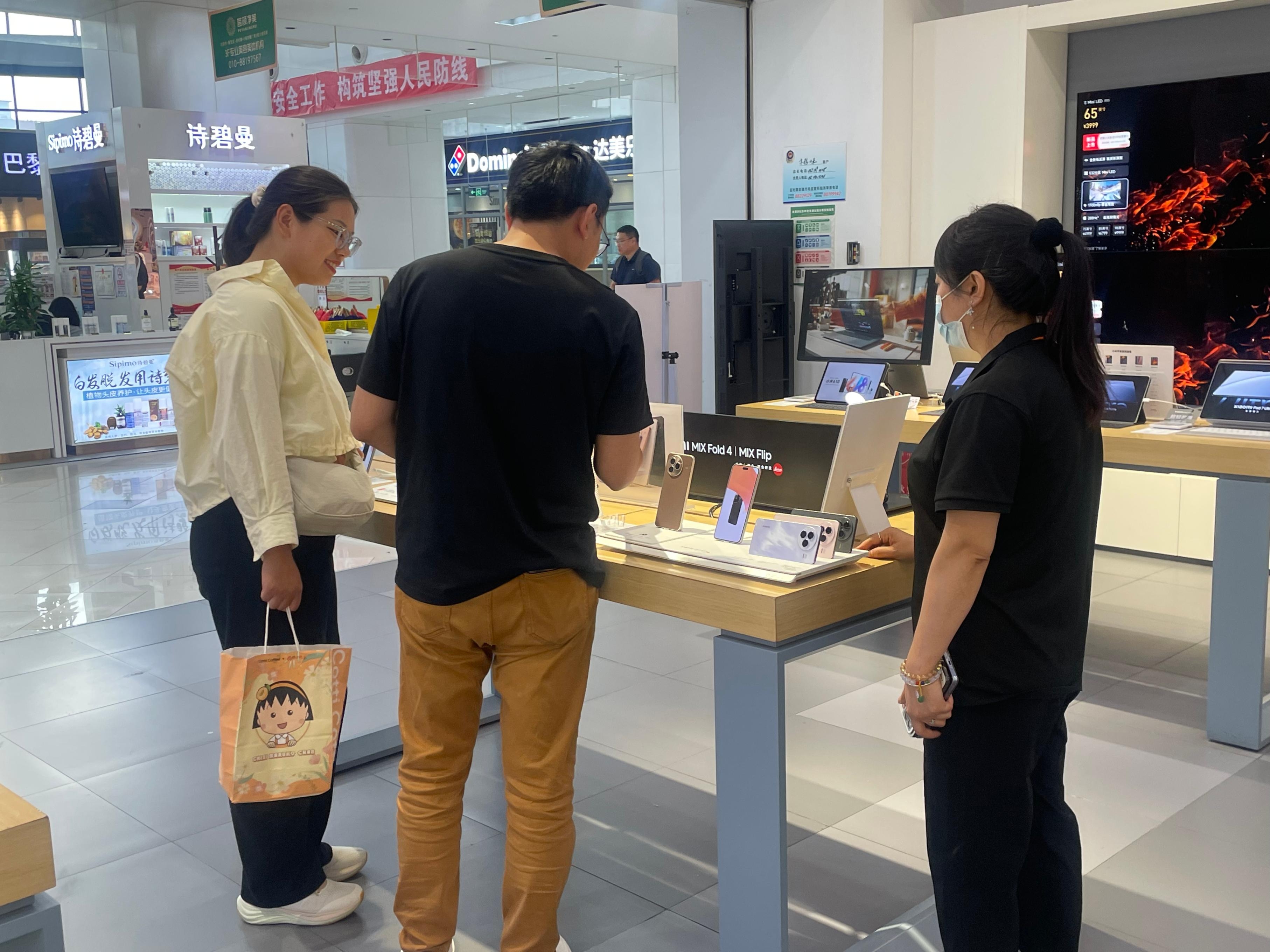 在北京市海淀区田村京粮广场内，市民们正在选购智能手机。 实习生 王琬迪摄