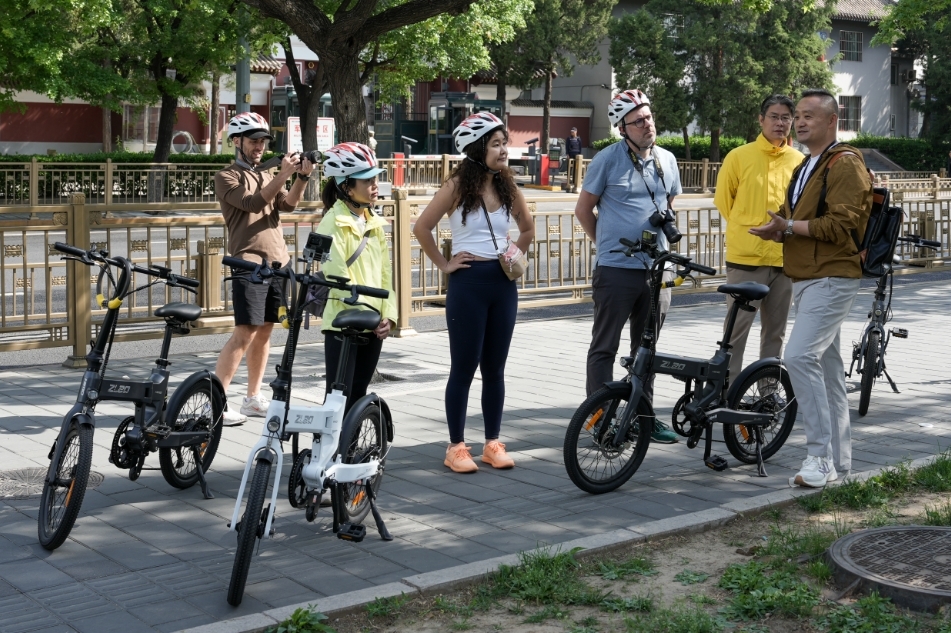 骑行游览北京中轴线的间隙，窦俊杰为游客讲解。受访者供图