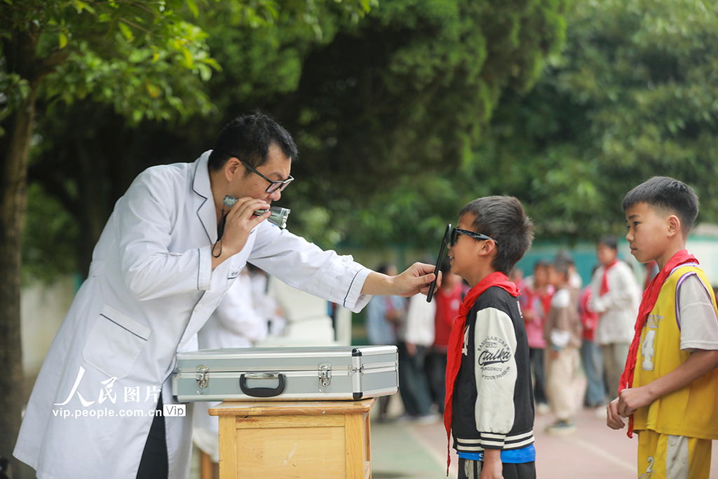 2025年6月4日，贵州省黔西市观音洞镇沙井小学内，眼科医生正在为学生进行四点融像功能筛查。周训超摄（人民图片网）