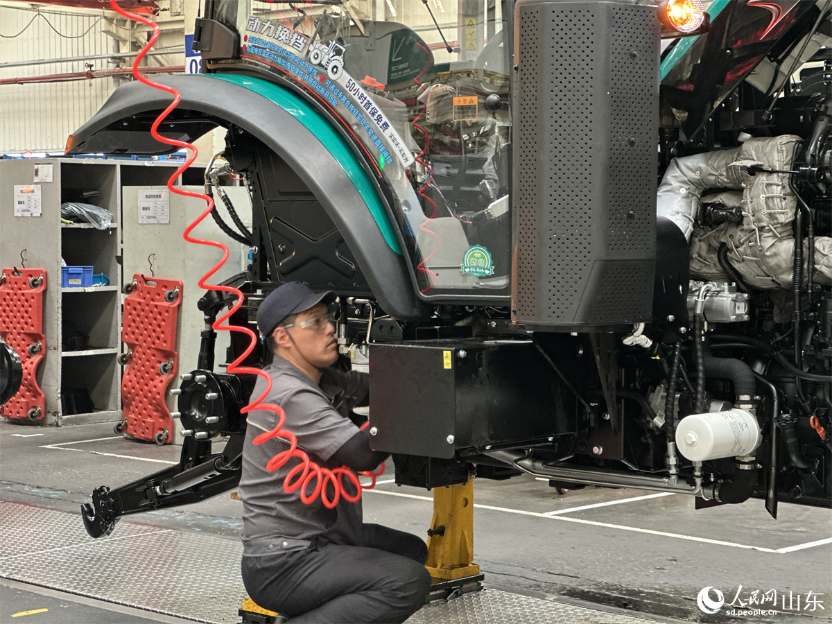 潍柴雷沃智慧农业科技股份有限公司拖拉机工厂总装车间，工人正在装配智能拖拉机。人民网 乔姝摄