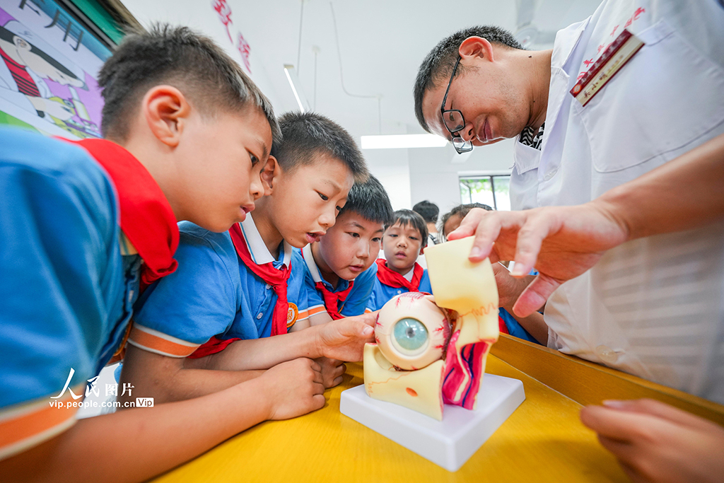 2025年6月5日，江西省抚州市南丰县登高小学，医生在向学生讲解眼睛的构造。谢东摄（人民图片网）