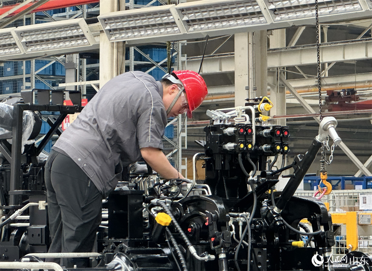 潍柴雷沃智慧农业科技股份有限公司拖拉机工厂总装车间，工人正在装配智能拖拉机。人民网 乔姝摄