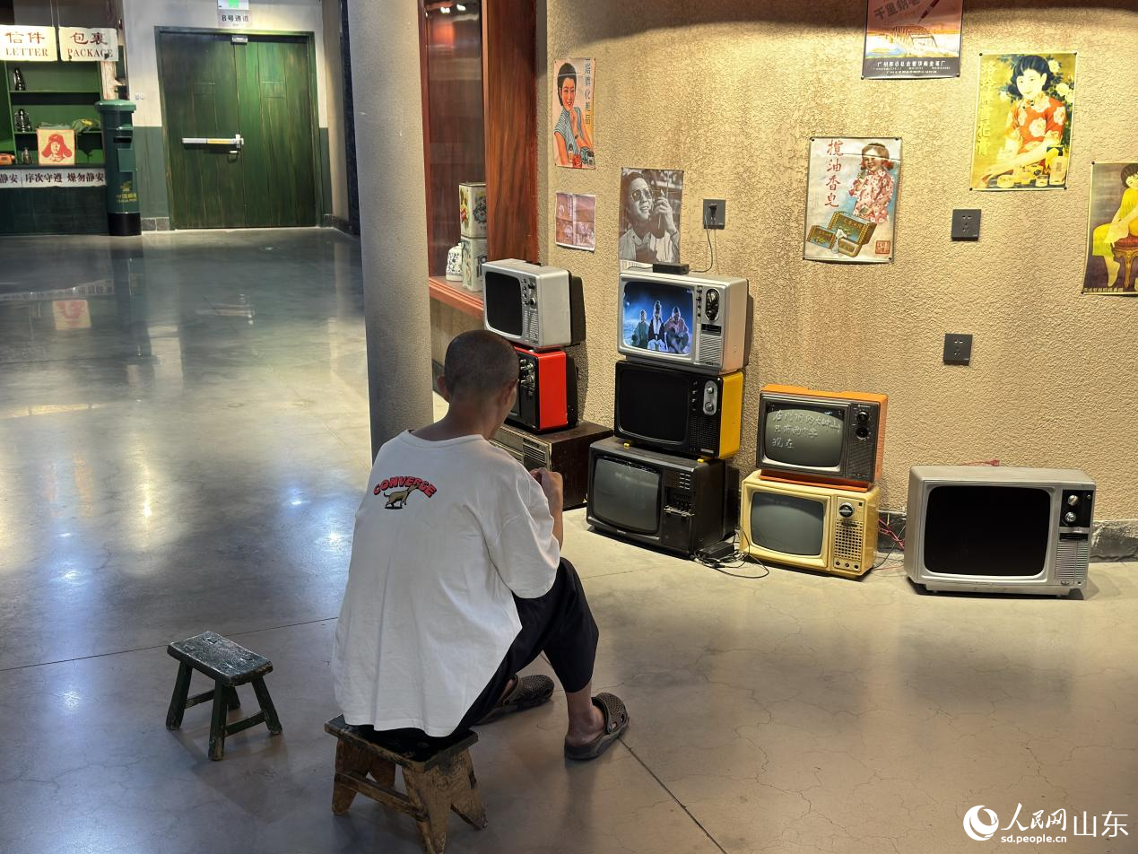 游客正在复古场景中看影片。人民网 庄润泽摄