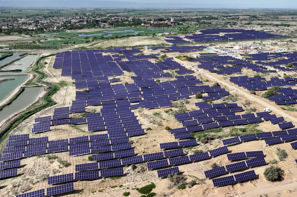 6月17日，在内蒙古巴彦淖尔市临河区新华林场光伏治沙项目区，光伏矩阵随着地势起伏错落排布（无人机照片）。新华社记者 李云平 摄