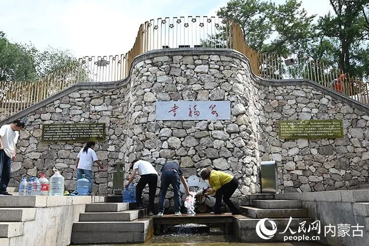 村民和游客来到东乌素图“幸福泉”打泉水。人民网记者 刘艺琳摄