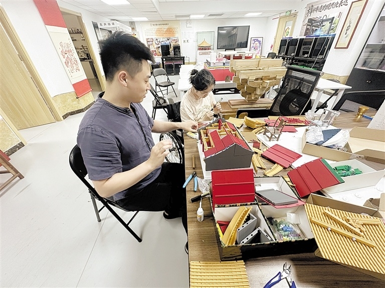 设计师王然（左）与何璐琦一起进行拼接零件、上色等工序。