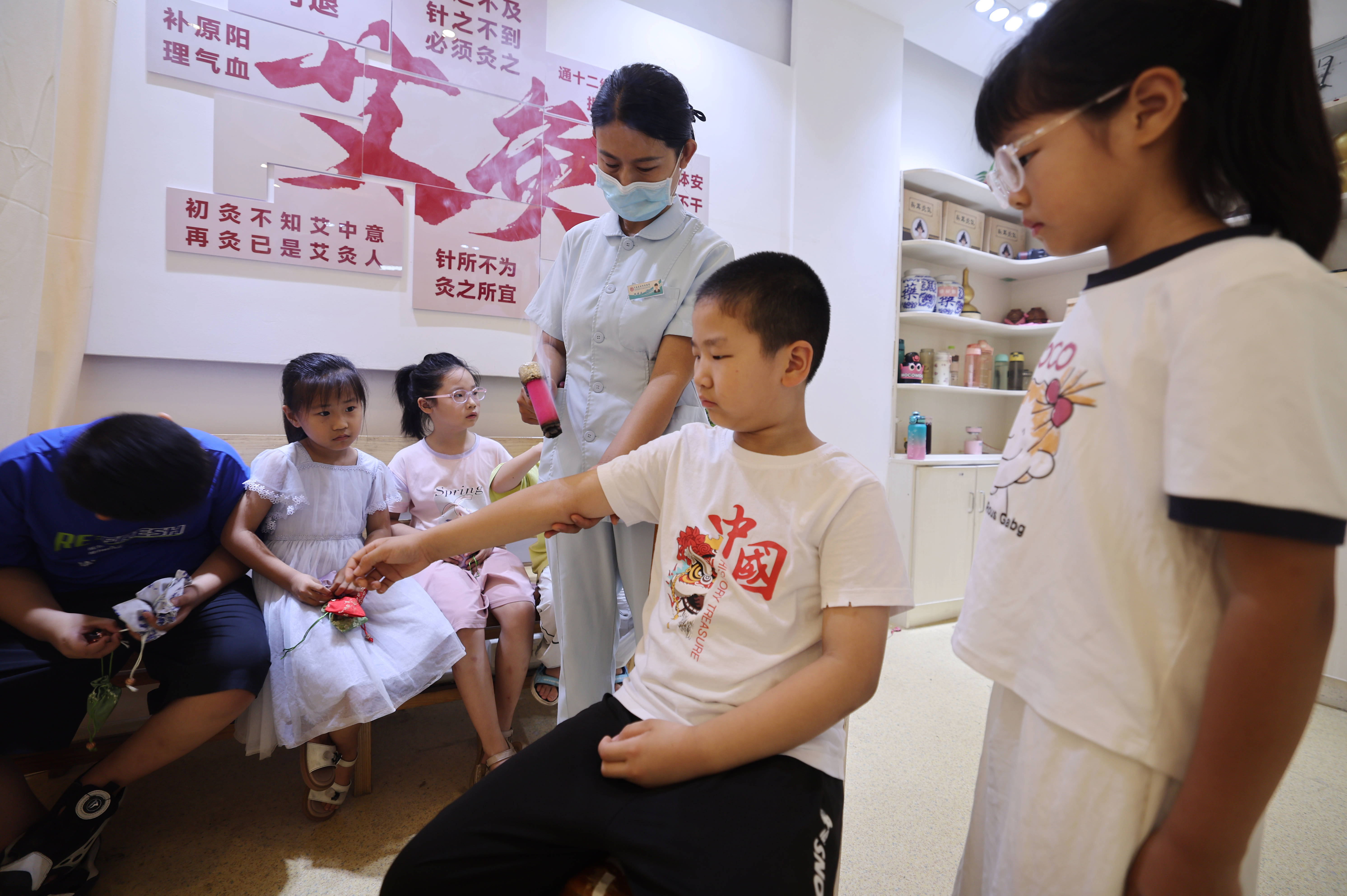 在沂南县妇幼保健院，小学生在体验艾灸疗法。