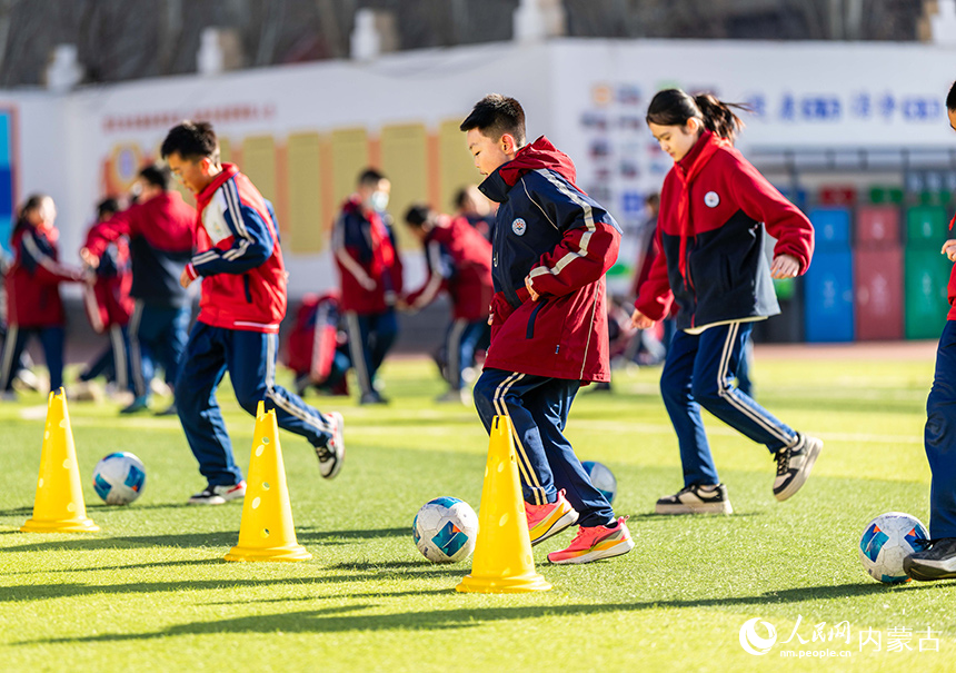 内蒙古呼和浩特市玉泉区石东路小学的学生在操场上进行足球技能训练。丁根厚摄